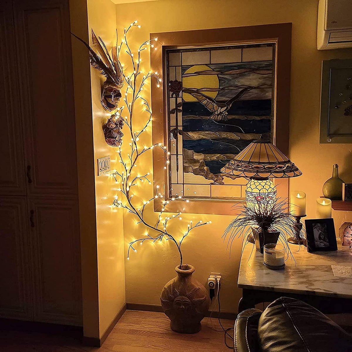 Decorative indoor setting with fairy lights, vase, and wall art.