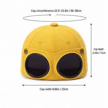 Yellow novelty cap with oversized round black visor-like front details, shown with measurement arrows and text indicating cap circumference, cap depth, and cap width on a white background.